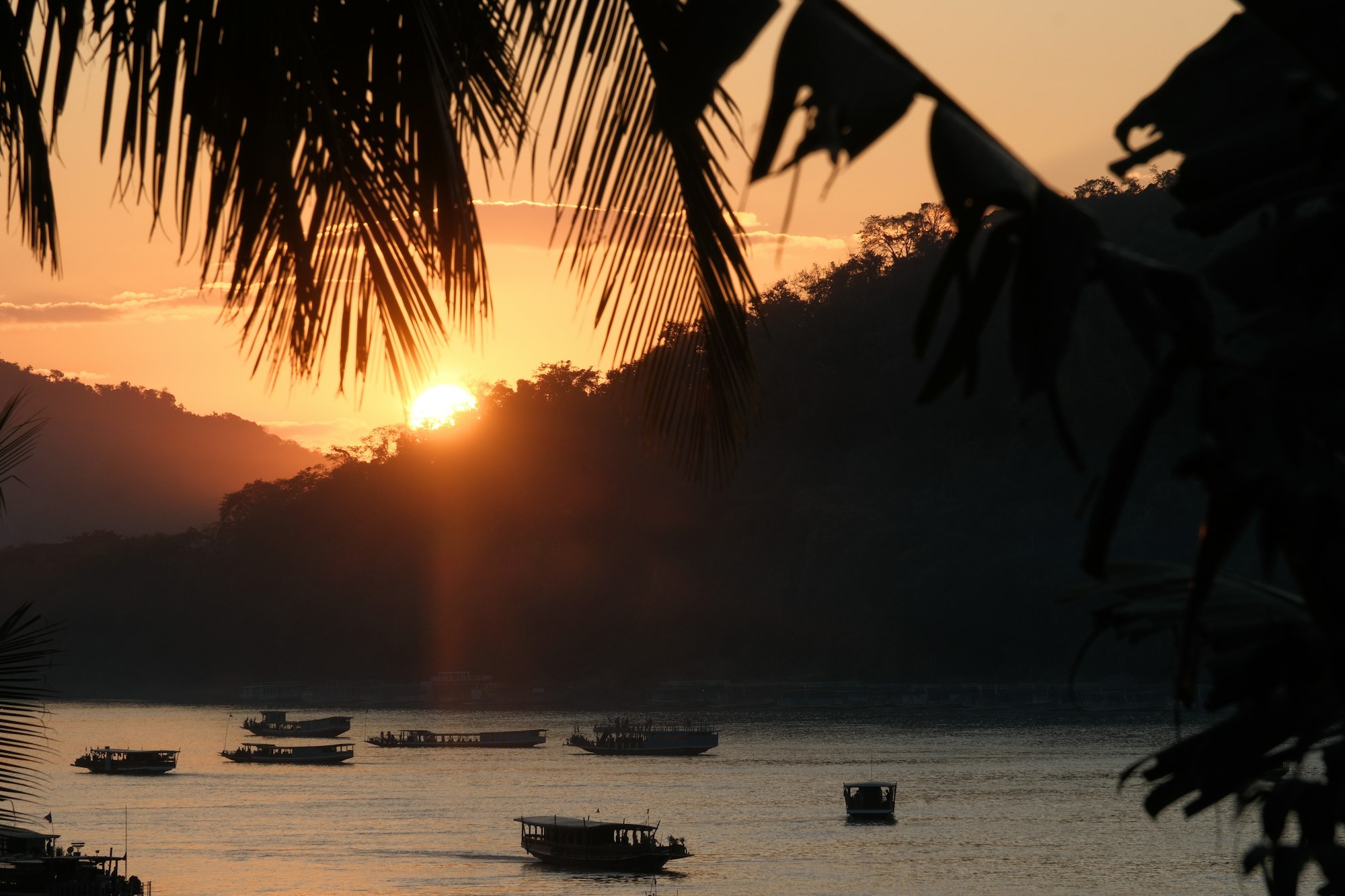 Des pirogues sur le Mékong à l'heure dorée, au Laos