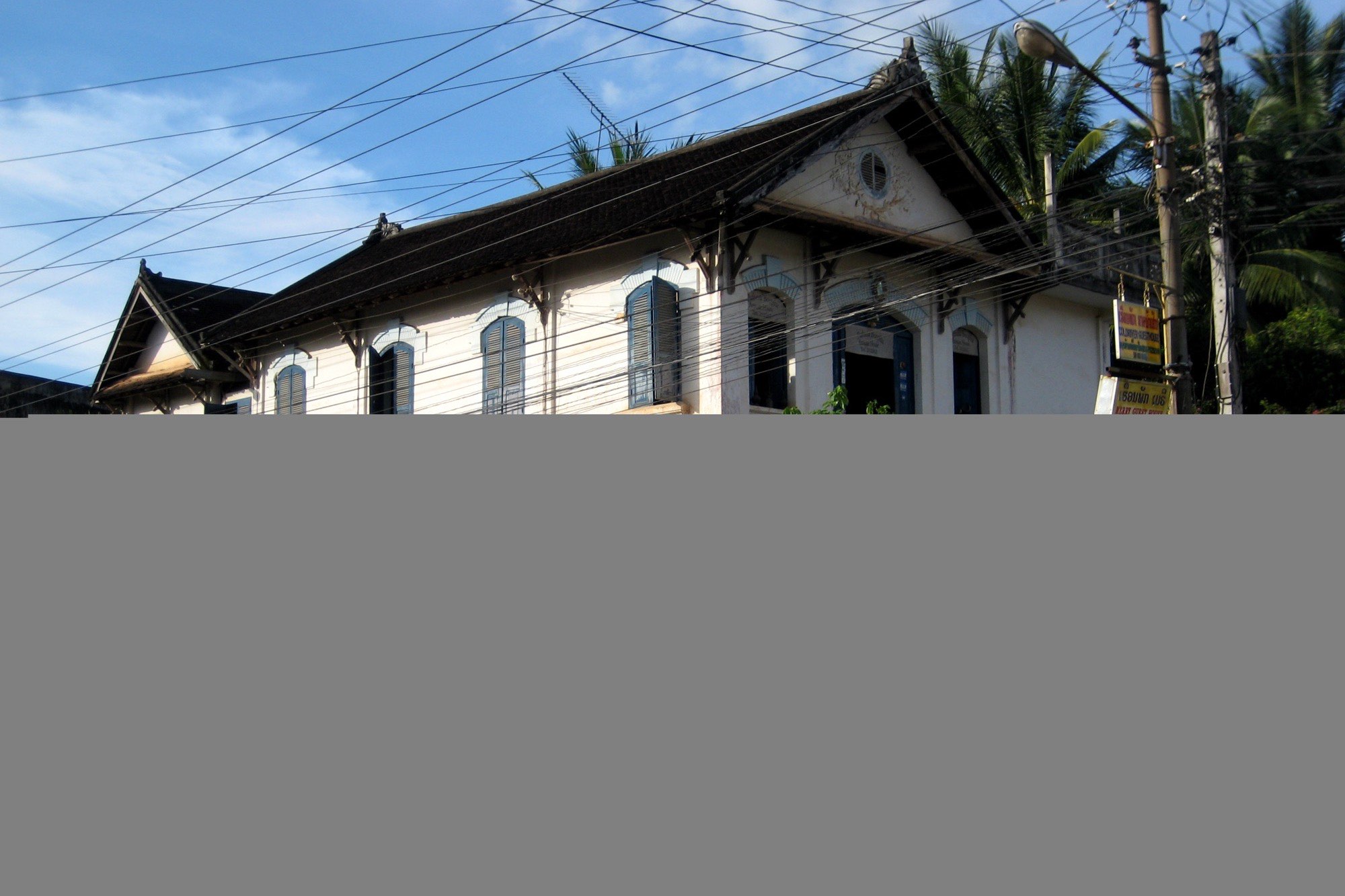 Une villa coloniale française patinée par le temps à Luang Prabang, volets et crépi ancien, une maison chargée d'histoire et de continuité