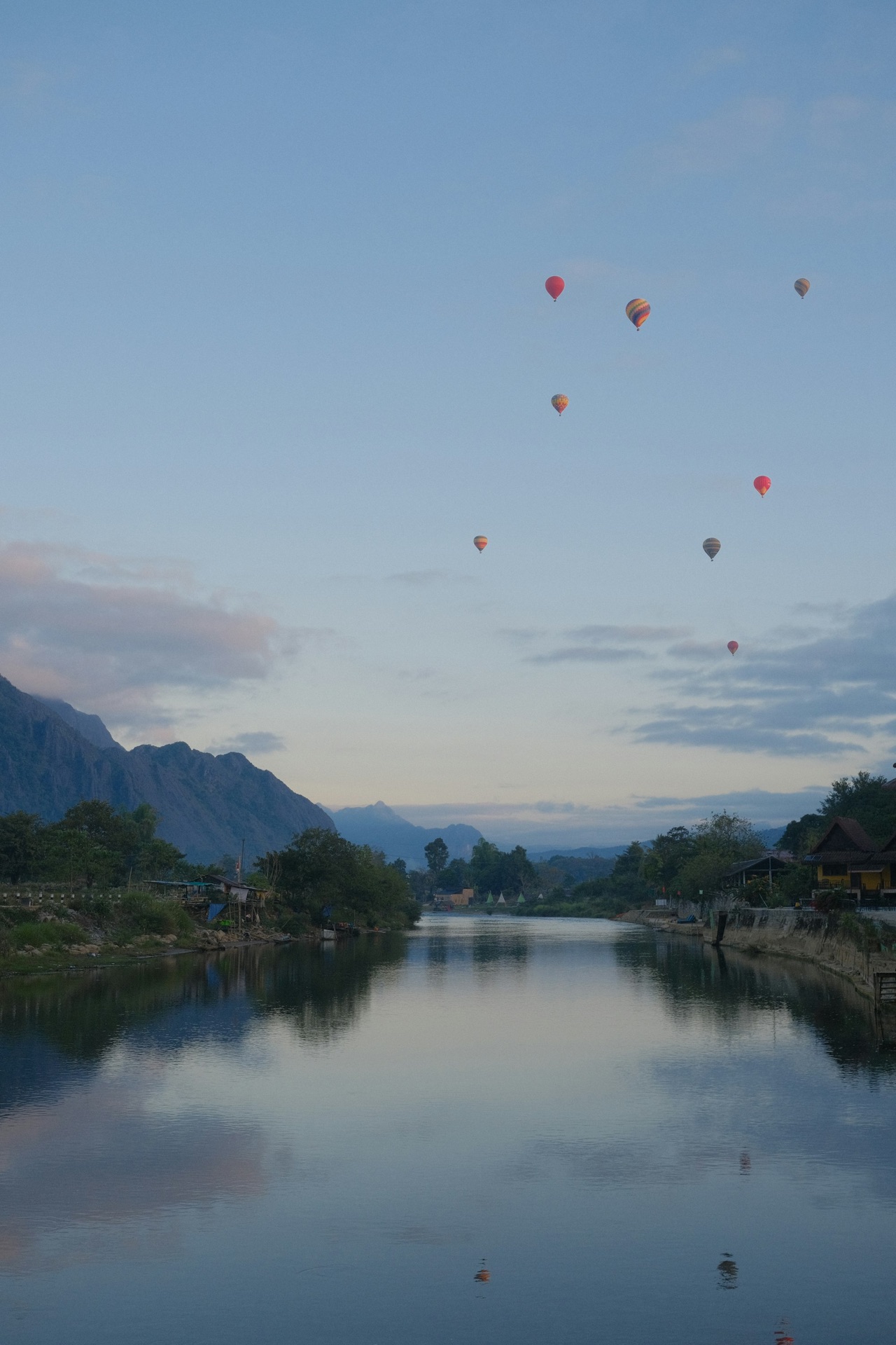 Hot-air balloons drifting over the karst mountains of Vang Vieng at dawn